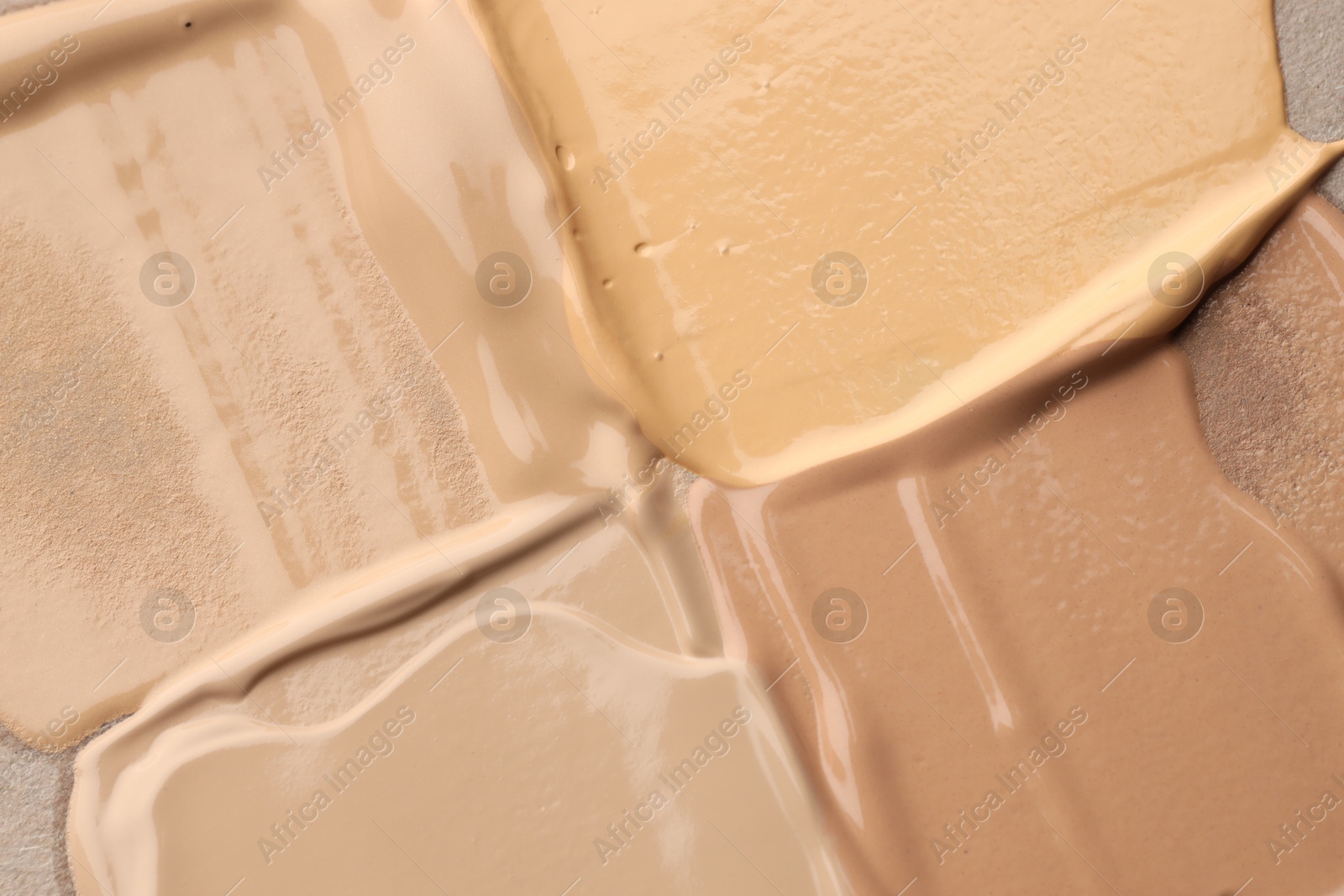 Photo of Colorful skin foundations as background, top view