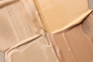Photo of Colorful skin foundations as background, top view