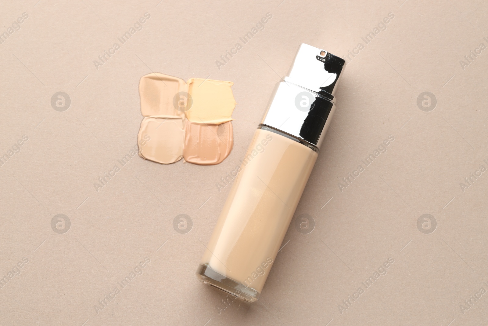 Photo of Colorful skin foundations and bottle on grey background, flat lay