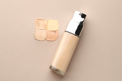 Photo of Colorful skin foundations and bottle on grey background, flat lay