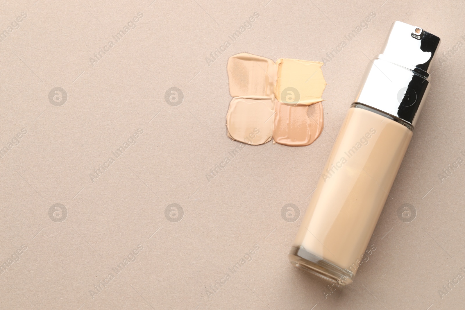 Photo of Colorful skin foundations and bottle on grey background, flat lay. Space for text
