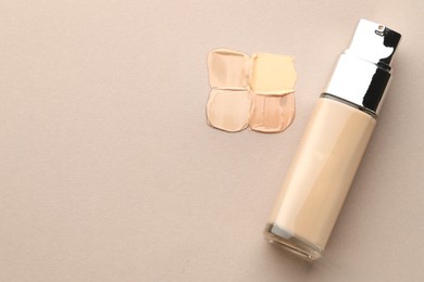 Photo of Colorful skin foundations and bottle on grey background, flat lay. Space for text