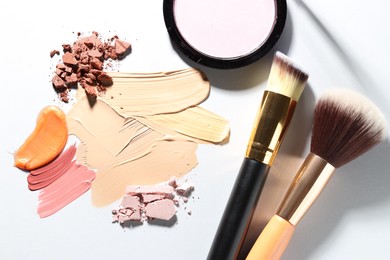 Photo of Different cosmetic products and makeup brushes on white background, flat lay