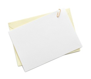 Photo of Blank invitation card and envelope isolated on white, top view. Space for design