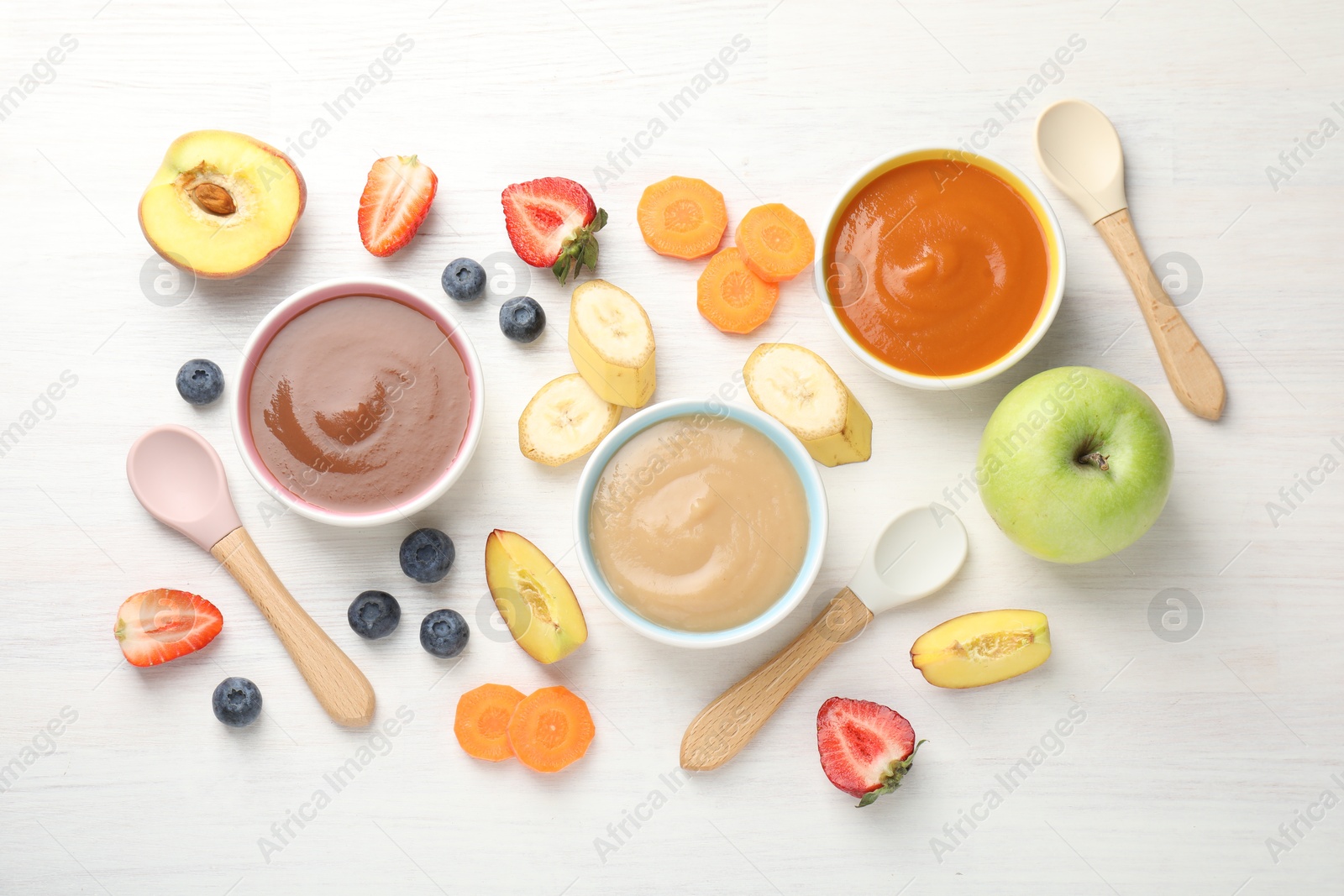 Baby food. Tasty puree in bowls and different ingredients on white wooden table, flat lay Photo of Baby food. Tasty puree in bowls and different ingredients on white wooden table, flat lay