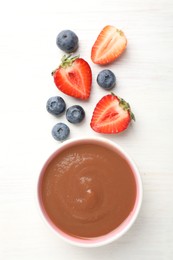 Photo of Baby food. Tasty puree in bowl and different ingredients on white wooden table, flat lay