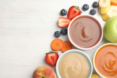 Photo of Baby food. Tasty puree in bowls and different ingredients on white wooden table, flat lay. Space for text