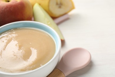 Photo of Baby food. Tasty puree in bowl and different ingredients on white table, closeup