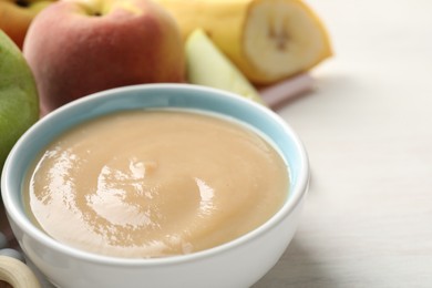 Photo of Baby food. Tasty puree in bowl and different ingredients on white table, closeup