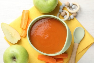 Photo of Baby food. Tasty puree in bowl, different ingredients and teether on white table, flat lay