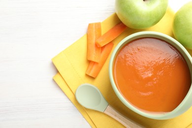 Photo of Baby food. Tasty puree in bowl, different ingredients and spoon on wooden table, flat lay. Space for text