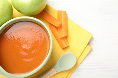 Photo of Baby food. Tasty puree in bowl, different ingredients and spoon on wooden table, flat lay. Space for text