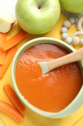 Photo of Baby food. Tasty puree in bowl, different ingredients and teether on table, flat lay