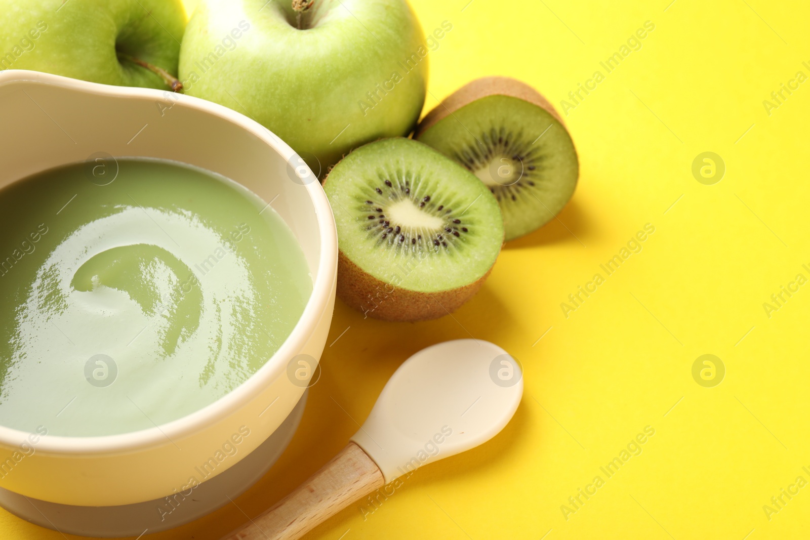 Baby food. Tasty puree in bowls and different ingredients on yellow background, above view. Space for text Photo of Baby food. Tasty puree in bowls and different ingredients on yellow background, above view. Space for text
