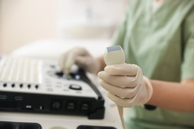 Photo of Professional sonographer with ultrasound machine in clinic, closeup