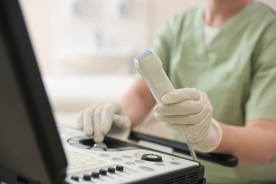 Photo of Professional sonographer with ultrasound machine in clinic, closeup