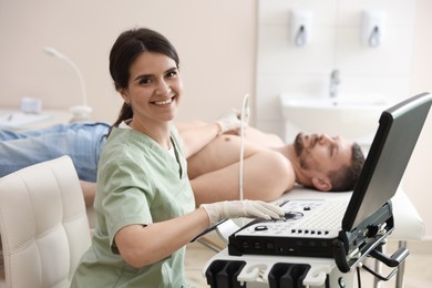 Photo of Sonographer conducting ultrasound examination of man's heart in clinic