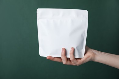 Photo of Woman with zipper stand-up pouch on green background, closeup. Mockup for design