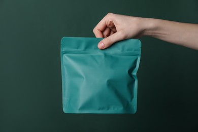 Photo of Woman with zipper stand-up pouch on green background, closeup. Mockup for design