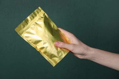 Photo of Woman with zipper stand-up pouch on green background, closeup. Mockup for design