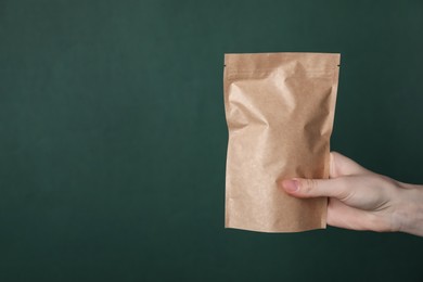 Photo of Woman with zipper stand-up pouch on green background, closeup. Mockup for design