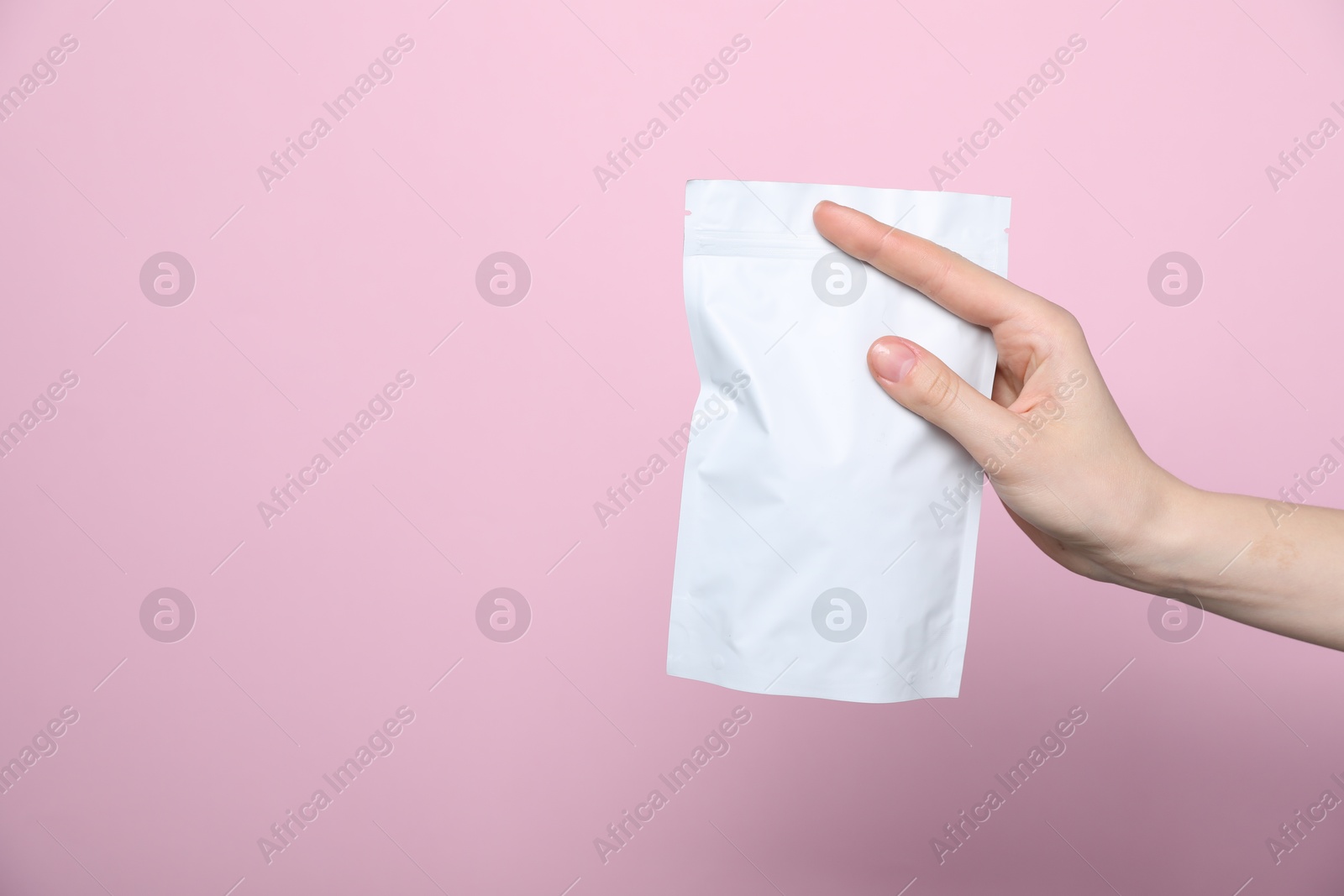 Woman with zipper stand-up pouch on pink background, closeup. Mockup for design Photo of Woman with zipper stand-up pouch on pink background, closeup. Mockup for design