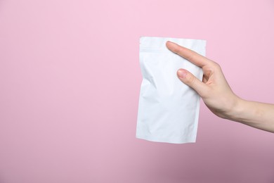 Photo of Woman with zipper stand-up pouch on pink background, closeup. Mockup for design
