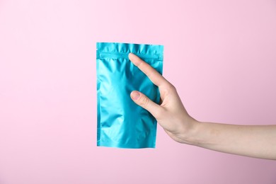 Photo of Woman with zipper stand-up pouch on pink background, closeup. Mockup for design