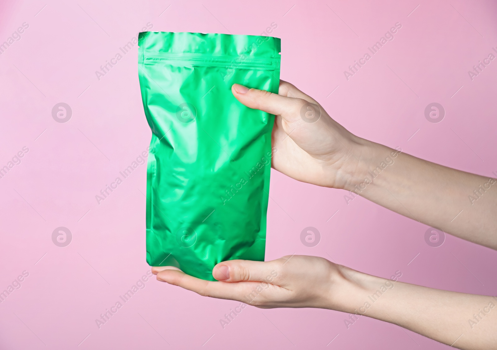 Woman with zipper stand-up pouch on pink background, closeup. Mockup for design Photo of Woman with zipper stand-up pouch on pink background, closeup. Mockup for design