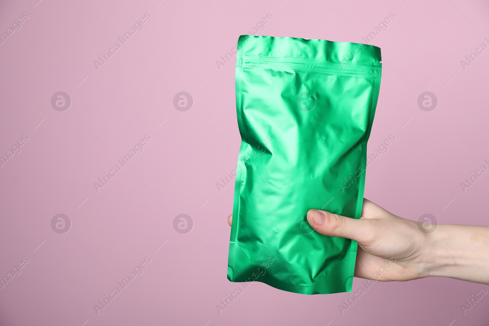 Photo of Woman with zipper stand-up pouch on pink background, closeup. Mockup for design