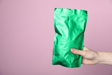 Photo of Woman with zipper stand-up pouch on pink background, closeup. Mockup for design