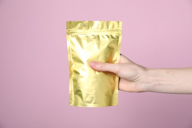 Photo of Woman with zipper stand-up pouch on pink background, closeup. Mockup for design