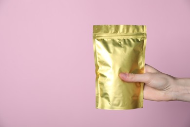 Photo of Woman with zipper stand-up pouch on pink background, closeup. Mockup for design