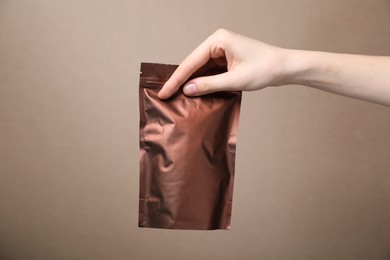 Photo of Woman with zipper stand-up pouch on beige background, closeup. Mockup for design