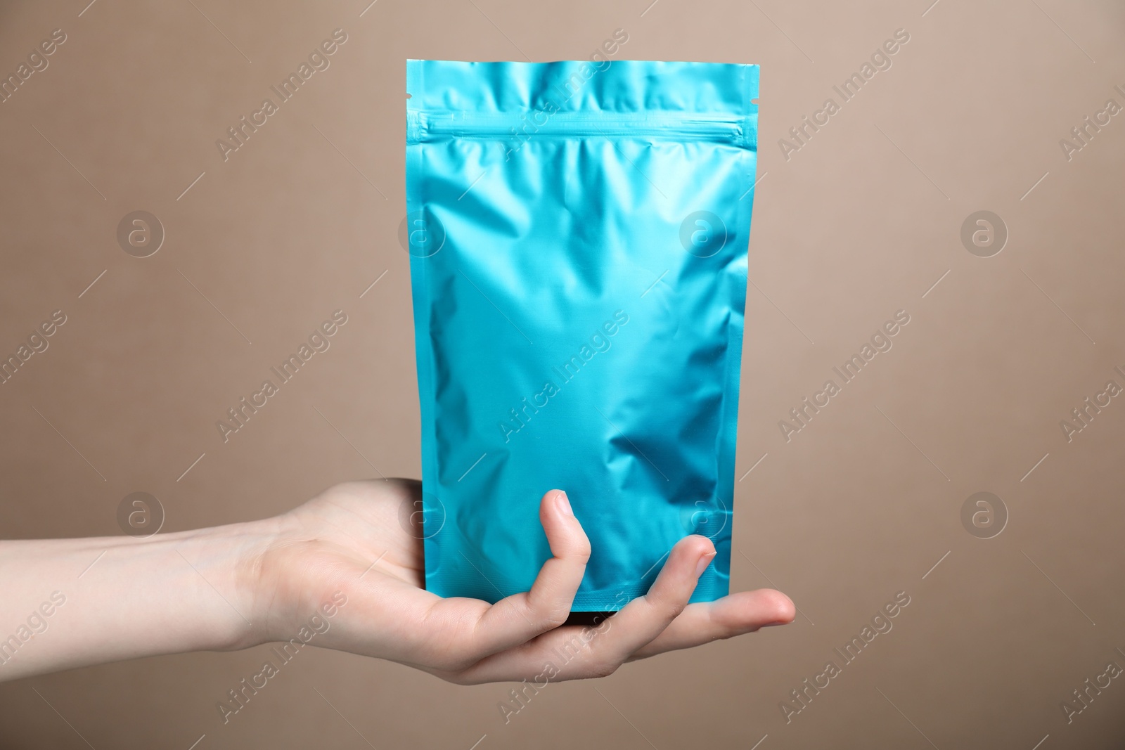Woman with zipper stand-up pouch on beige background, closeup. Mockup for design Photo of Woman with zipper stand-up pouch on beige background, closeup. Mockup for design