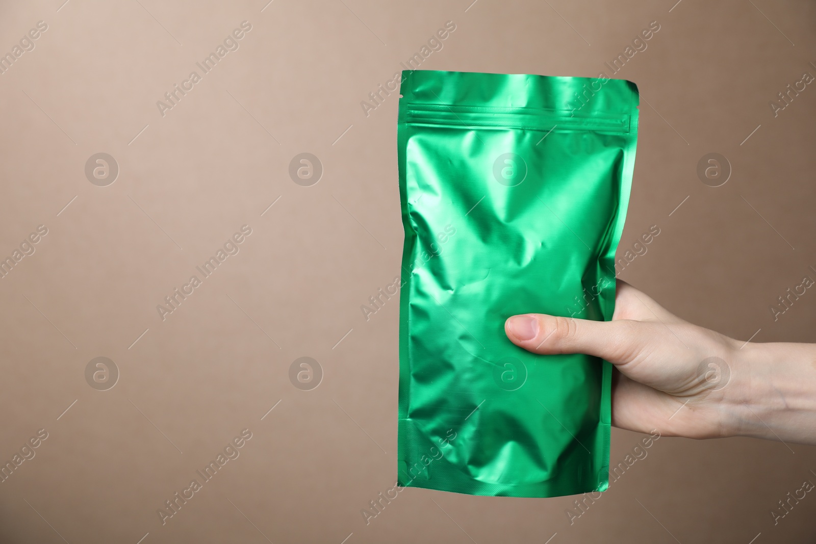 Woman with zipper stand-up pouch on beige background, closeup. Mockup for design Photo of Woman with zipper stand-up pouch on beige background, closeup. Mockup for design