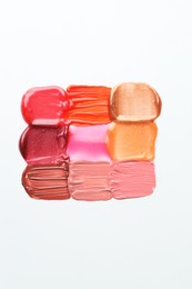 Photo of Colorful lip glosses on white background, flat lay