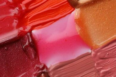 Photo of Colorful lip glosses as background, top view