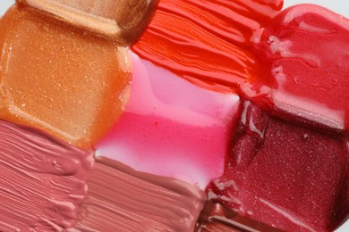 Photo of Colorful lip glosses as background, top view