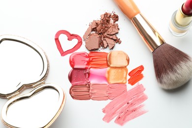 Photo of Different cosmetic products, mirror and makeup brush on white background, flat lay