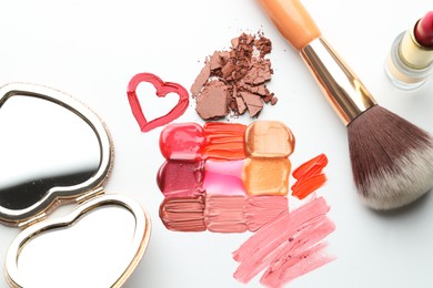Photo of Different cosmetic products, mirror and makeup brush on white background, flat lay