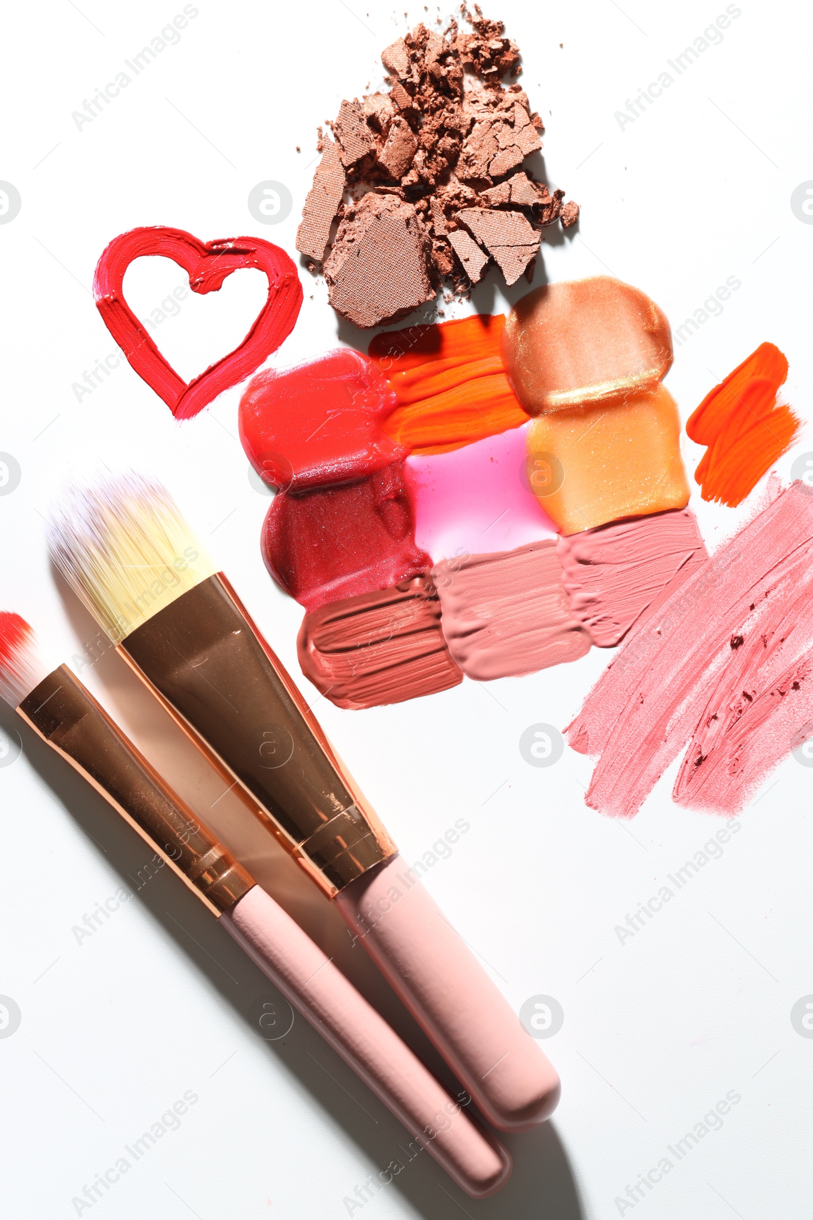 Different cosmetic products and makeup brushes on white background, flat lay Photo of Different cosmetic products and makeup brushes on white background, flat lay