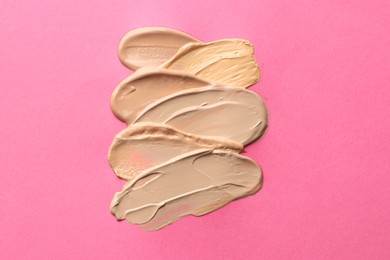 Photo of Colorful skin foundations on magenta background, above view