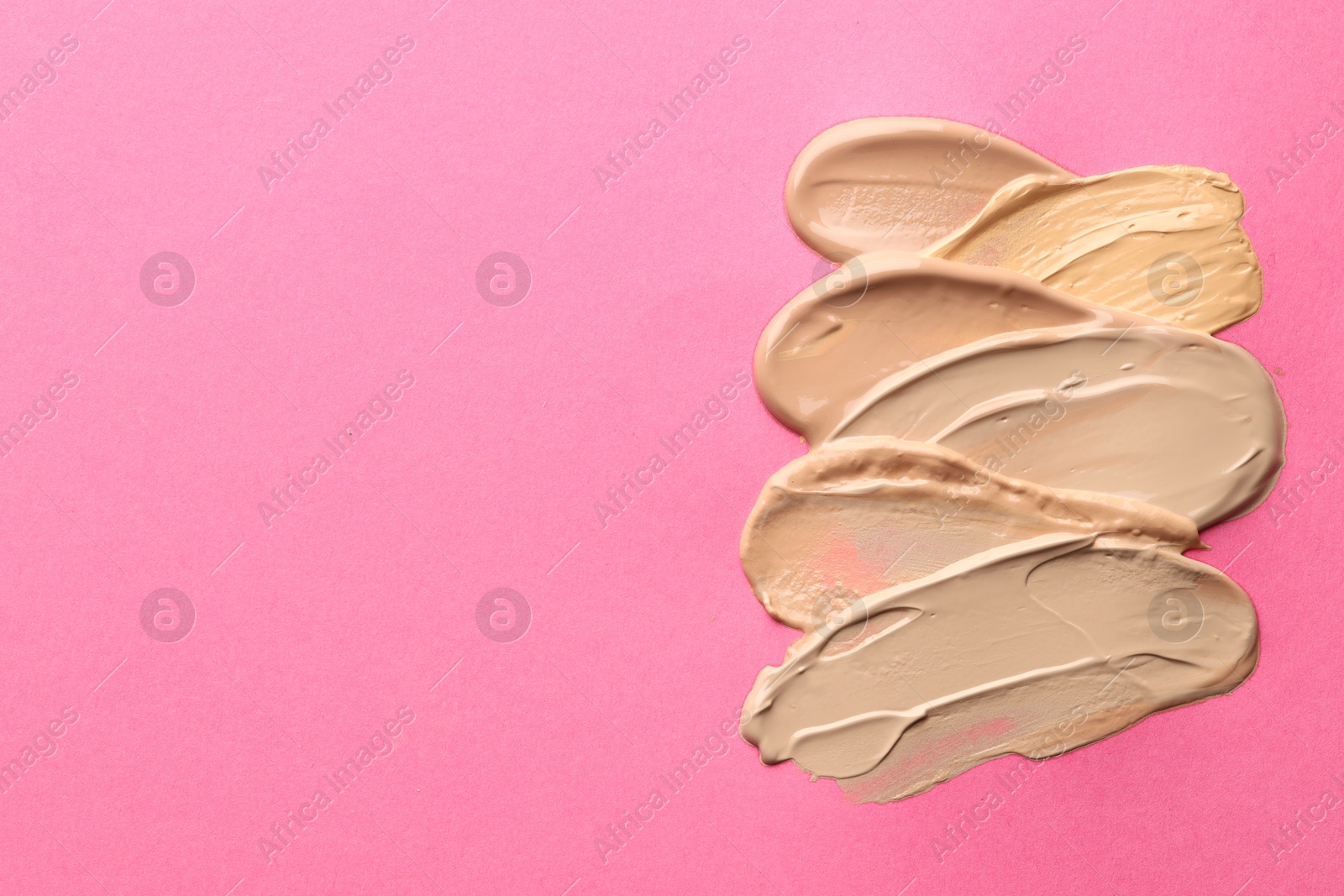 Colorful skin foundations on magenta background, above view. Space for text Photo of Colorful skin foundations on magenta background, above view. Space for text