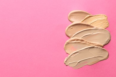 Photo of Colorful skin foundations on magenta background, above view. Space for text