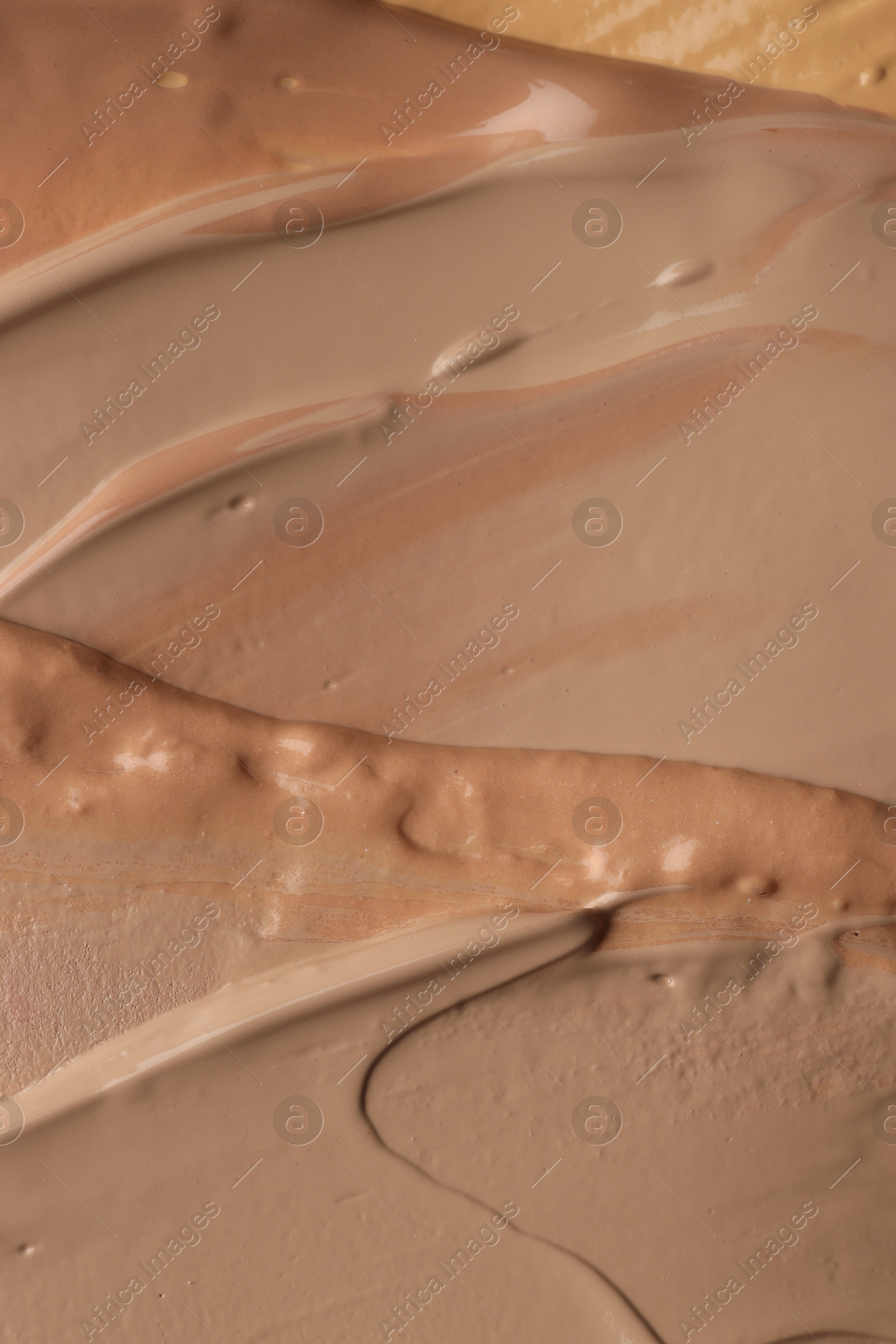 Photo of Colorful skin foundations as background, top view