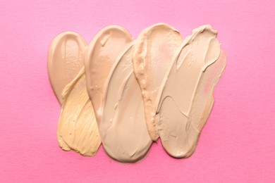Photo of Colorful skin foundations on magenta background, flat lay