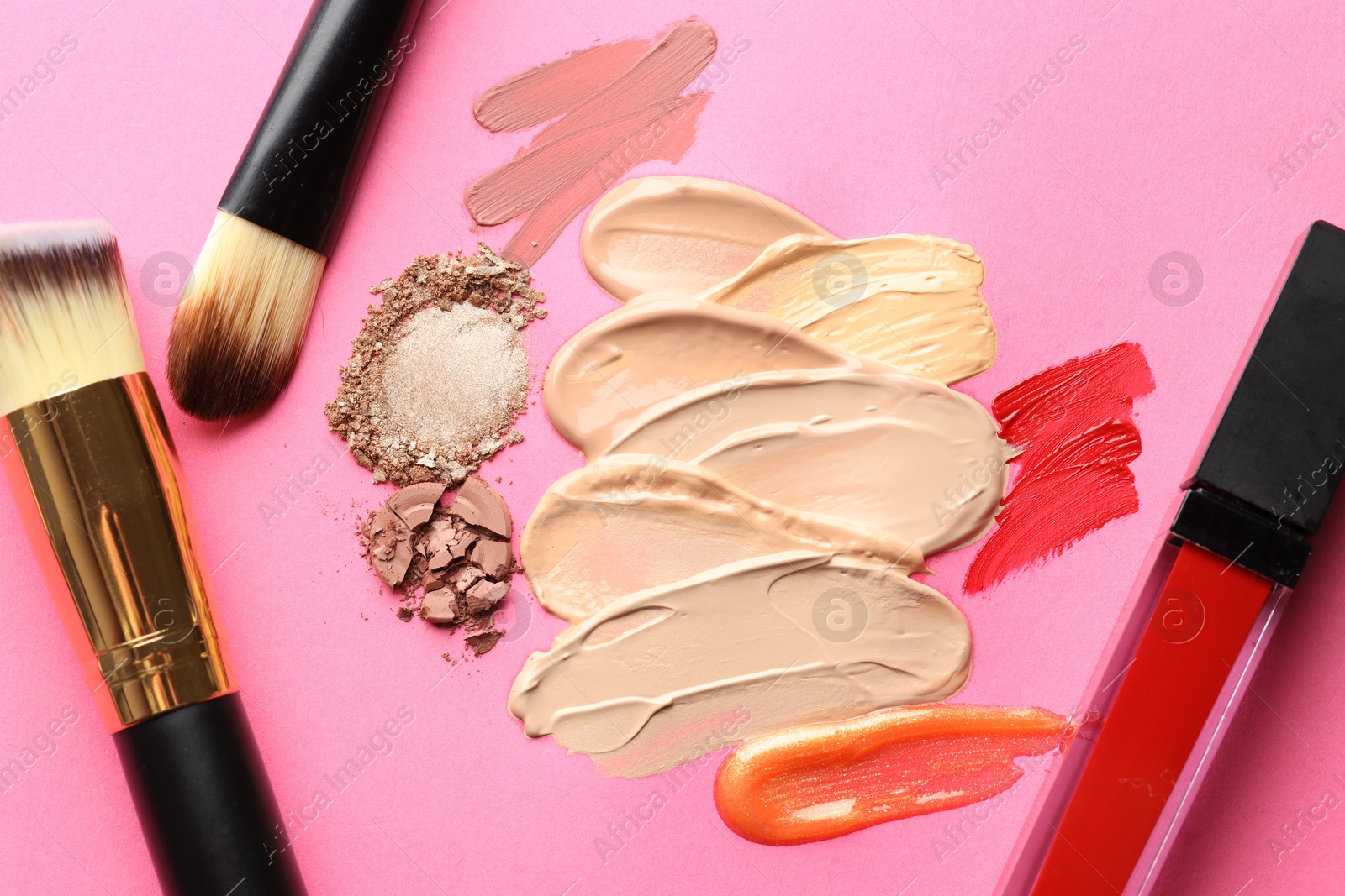 Different cosmetic products and makeup brushes on magenta background, flat lay Photo of Different cosmetic products and makeup brushes on magenta background, flat lay