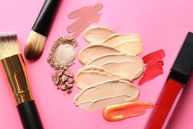 Photo of Different cosmetic products and makeup brushes on magenta background, flat lay