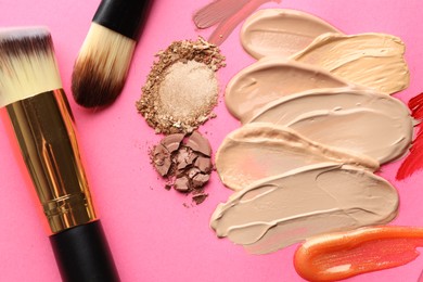 Photo of Different cosmetic products and makeup brushes on magenta background, flat lay
